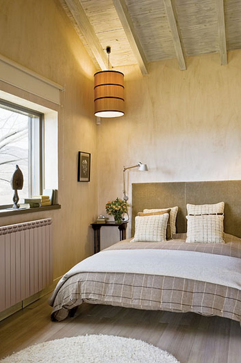 Zabawa światłem. Na suficie żyrandol z drukowanego jedwabiu. Przy wezgłowiu łóżka aluminiowe lampki.