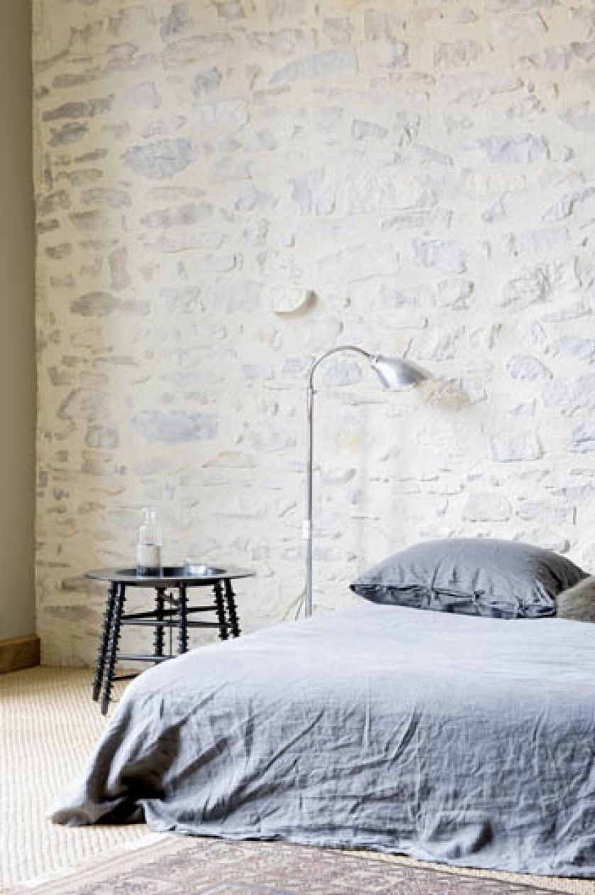 Żeby ocieplić surowe kamienne wnętrza wybrano spokojne kolory: od kremowych po beże i dołożono do tego najbardziej miękkie ze