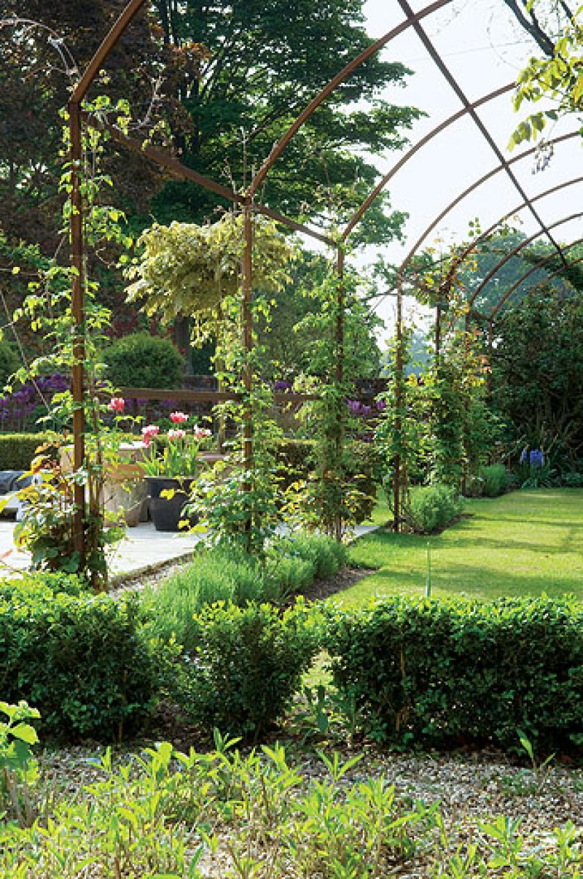 Dwa hektary otoczone wodą, z resztkami starych ceglanych murów, różanymi pergolami, równiutkimi żywopłotami. Im dalej