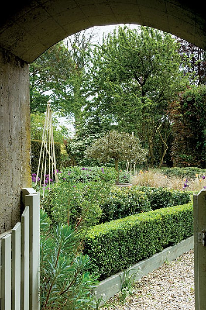 Dwa hektary otoczone wodą, z resztkami starych ceglanych murów, różanymi pergolami, równiutkimi żywopłotami. Im dalej