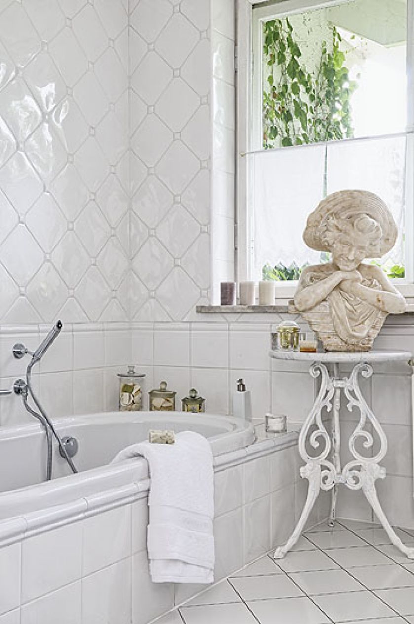 Łazienka w aranżacji rodem z Półwyspu Iberyjskiego: białe, hiszpańskie kafelki i XIX-wieczna rzeźba.