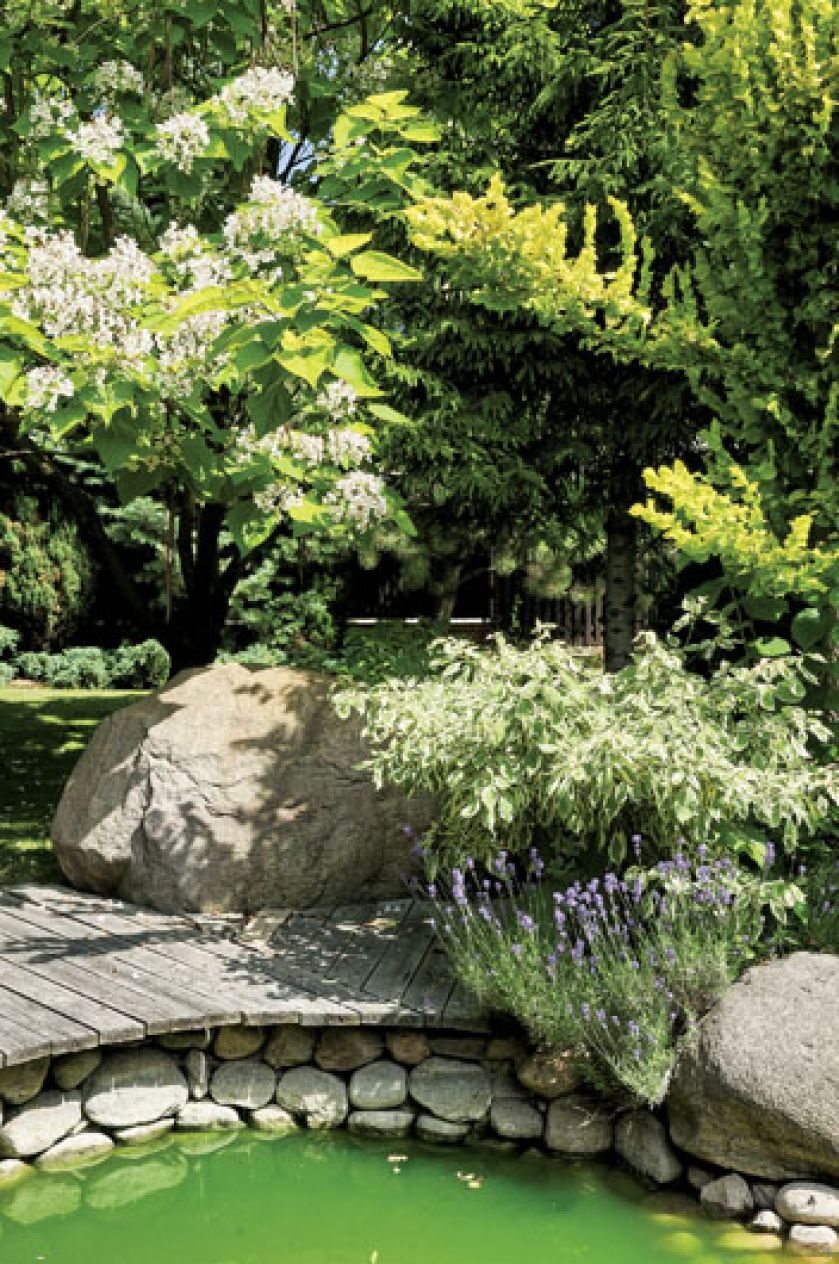 Kominek i dwa grile to sprzęty niezbędne w letniej kuchni. Ogród miłosników podróży i gotowania.