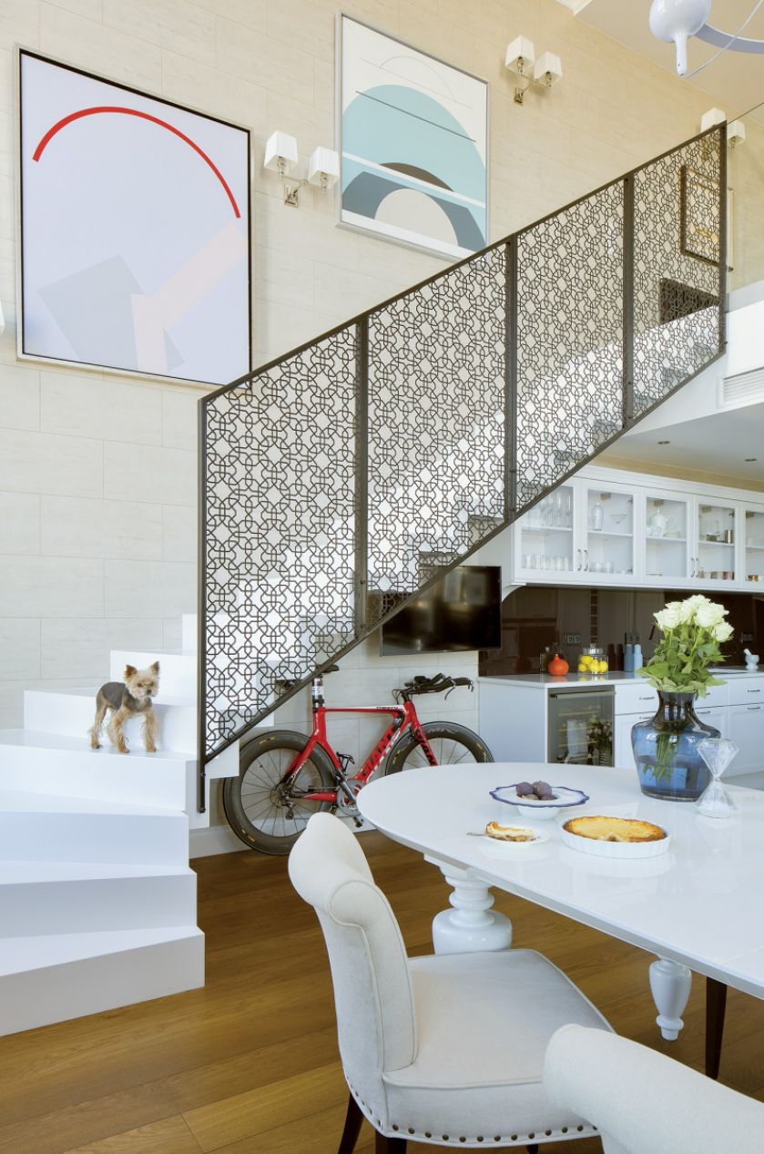 Ozdobą prostych dębowych schodów pomalowanych na biało jest ażurowa balustrada cięta laserowo z blachy. Jej