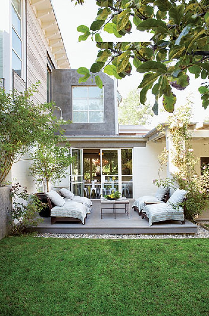 Drewniany podest, z którego jest zejście bezpośrednio na trawę ogrodu.