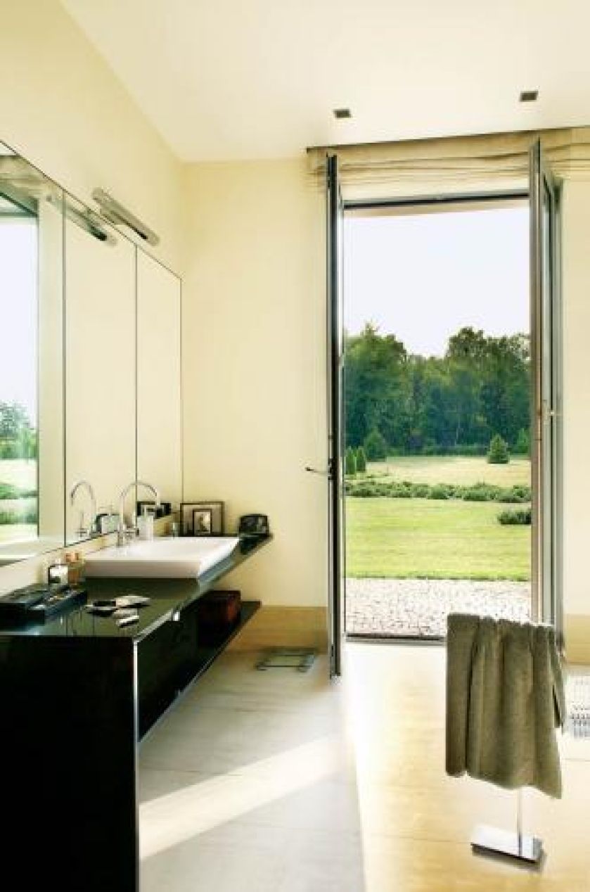 W tym domu można wyjść do ogrodu z każdego pokoju- także kąpielowego. Mocnym akcentem w łazience jest blat z