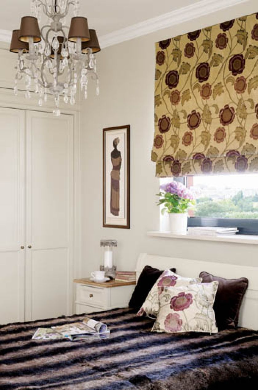 Zdecydowany kwiatowy wzór na tkaninach i kolor bakłażana świetnie uzupełniają delikatne meble w kolorze ecru.
