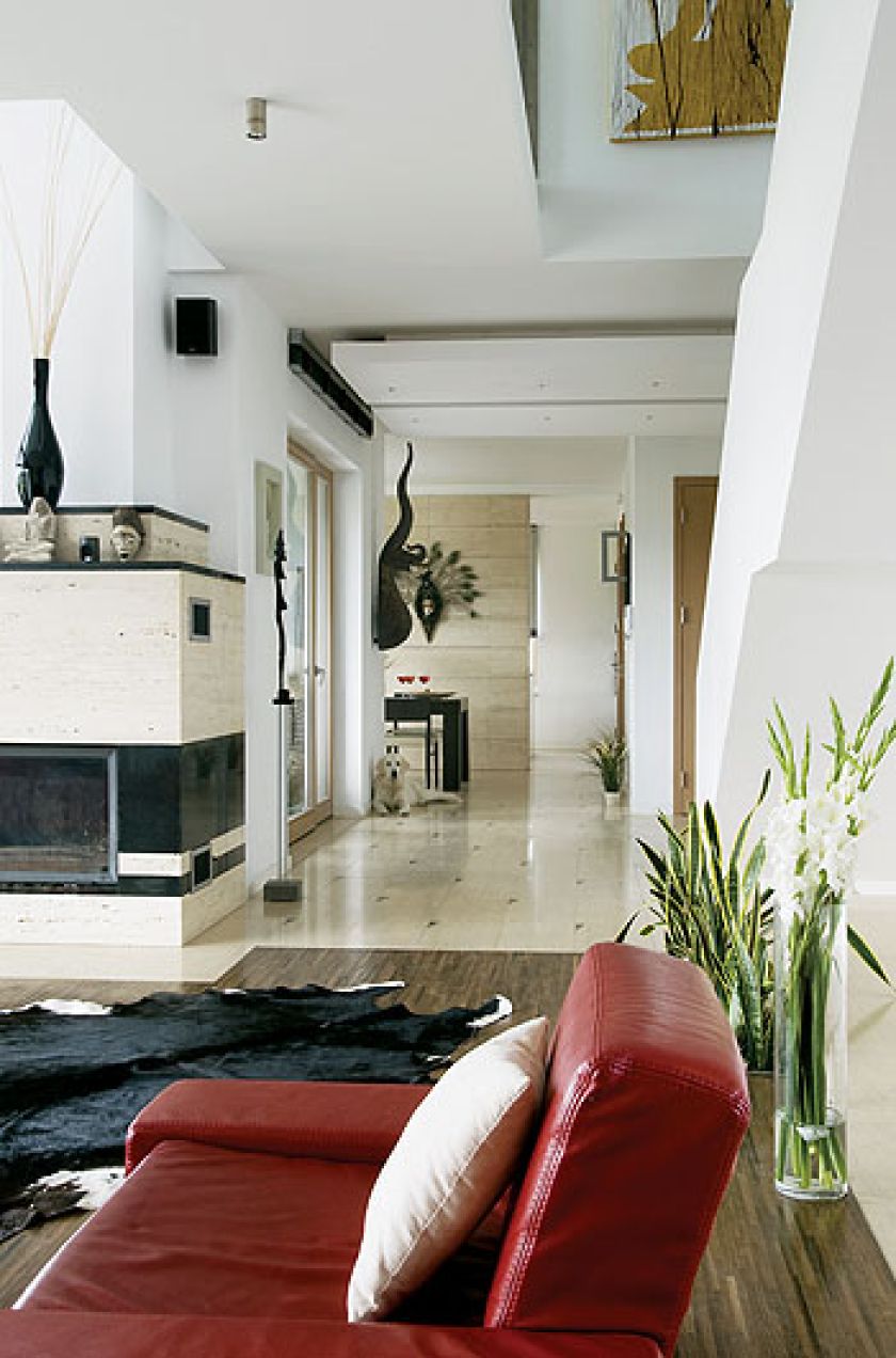 W salonie z trawertynowo-granitowym kominkiem stanęła duża afrykańska rzeźba z Konga.