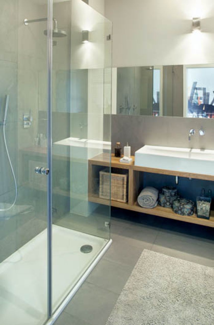 Dzięki drewnianym półkom łazienka jest przytulna i kojarzy się z ciepłem.