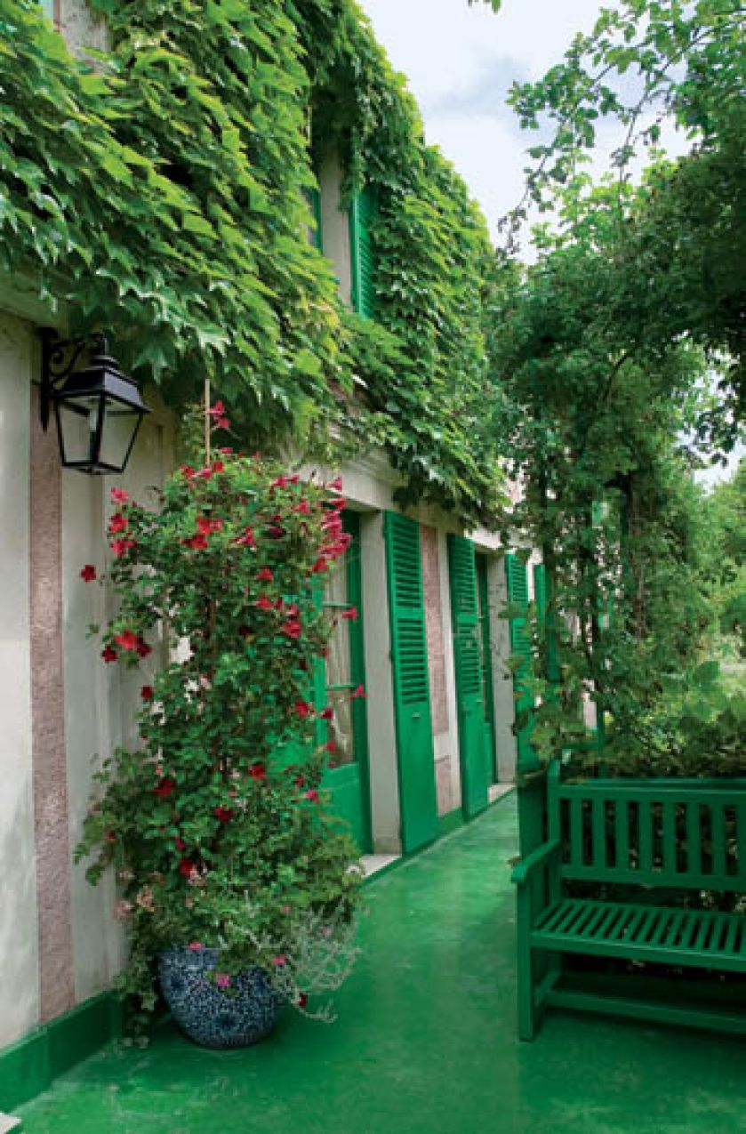 Zielone okiennice i elementy małej architektury ogrodowej sprawiaj, że dom wtapia się w ogród.