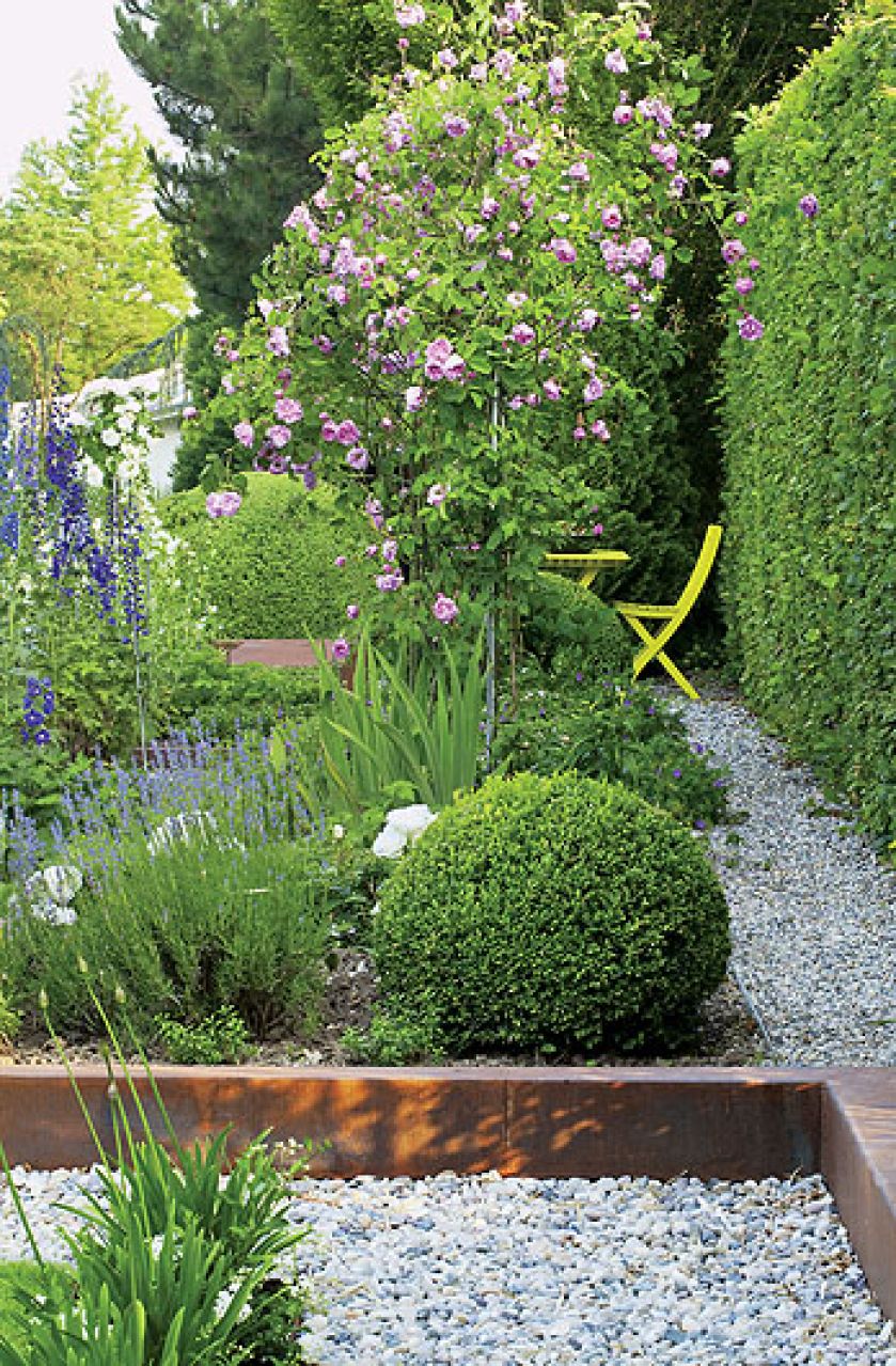 Ogród zaczyna się po miejsku: murawa, ścieżki wysypane żwirem lub wyłożone otoczakami, przycięte w kule