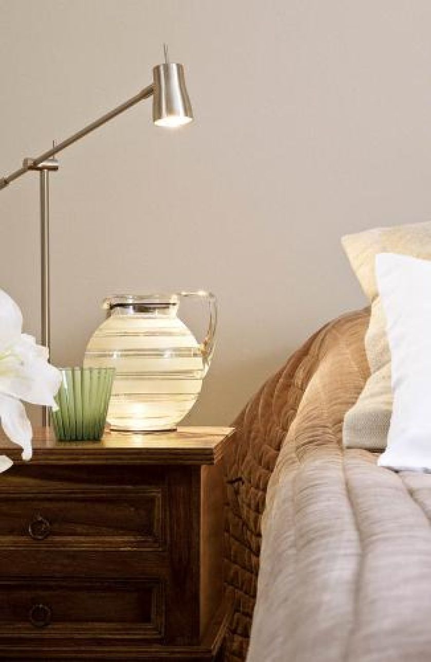 Przy łóżku dzbanek i szklanka. Dom gościnny