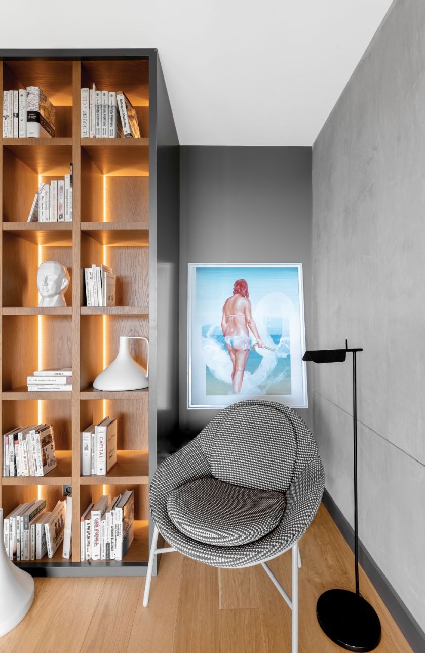 Podświetlona biblioteka nie tylko ładnie wygląda, sprawia też, że w lofcie robi się przytulniej. Fotel