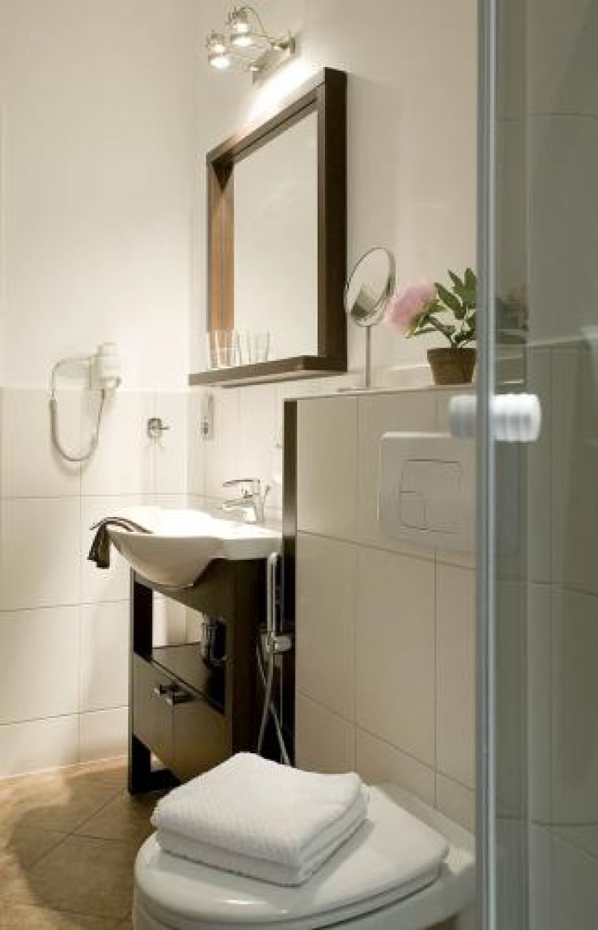 Ciemna rama lustra akcentuje jasne ściany.