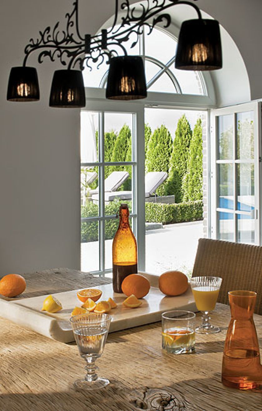 Biało-czarna nowoczesna kuchnia wycisza rozmach reszty domu. Nie brak w niej ciepłuch akcentów: pasiastej tapety