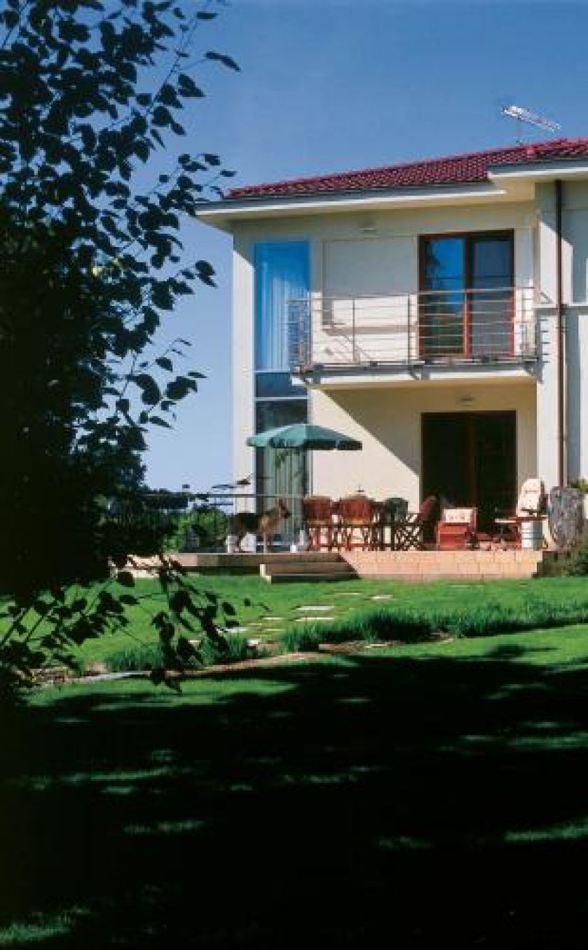 Dom otacza uporządkowany ogród. Nad rzeczką, pośród traw