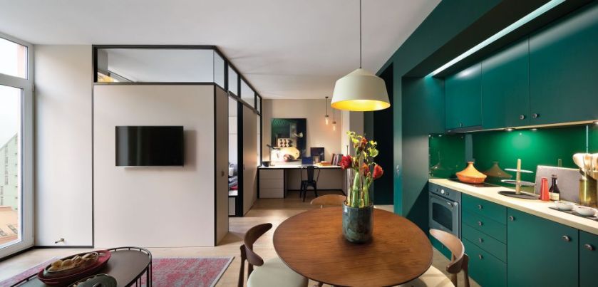 Przykład zagospodarowania kuchni, salonu i pracowni w jednym pomieszczeniu, bez oddzielania stref ścianami. To pomysł