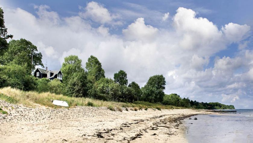 Dom usytuowany jest tuż przy plaży. Drewniany dom nad morzem