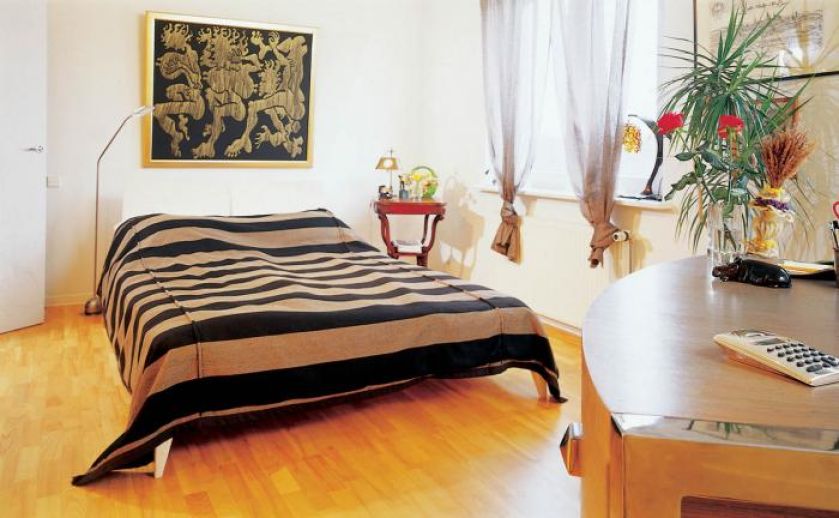 Kobieca sypialnia urządzona w ciepłych kolorach.