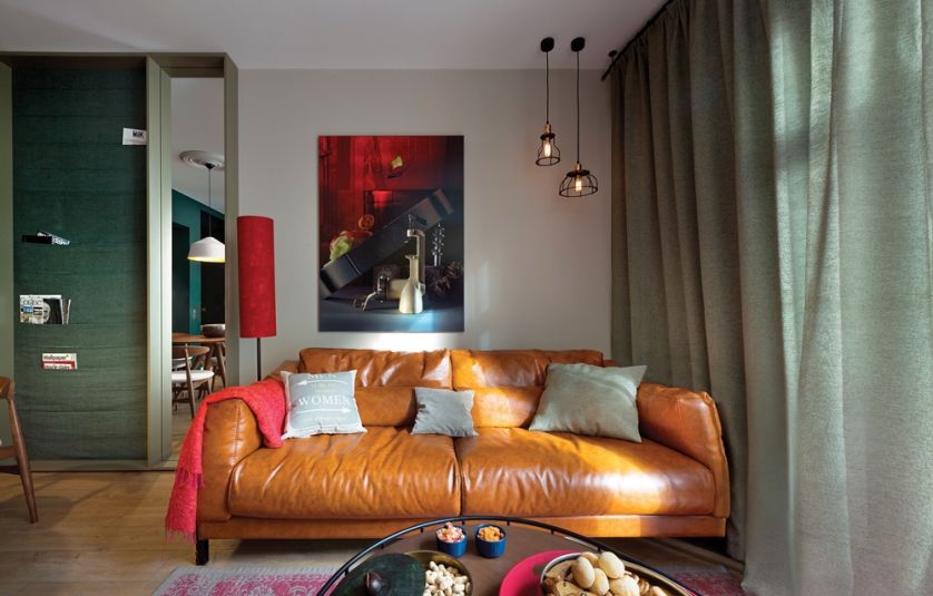 Asymetryczne zawieszenie lamp na suficie jest zrównoważone dzięki obrazowi.