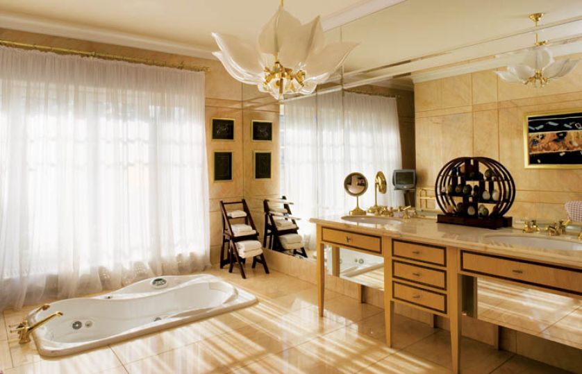 Pokój kąpielowy rozświetlają ogromne francuskie okna i żyrandol z weneckiego szkła.