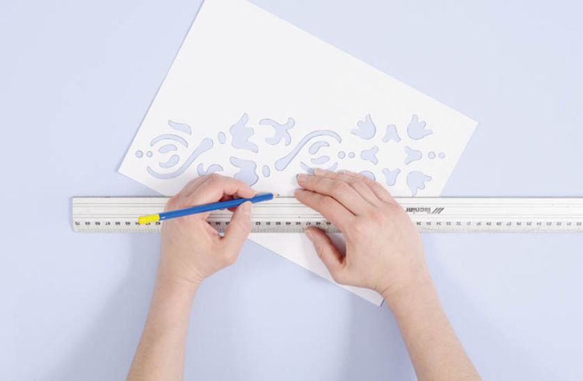 Ponieważ wzór biegnie po przekątnej szablonu, linię narysuj także na szablonie i go ustaw, aby linia na ścianie i