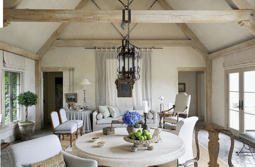 Kamienny stół i kute żyrandole nadają wnętrzu prowansalskiego klimatu.