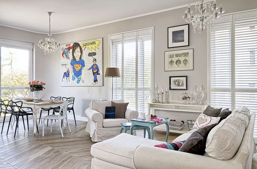 Tłem dla sztuki są białe ściany i jasne meble.