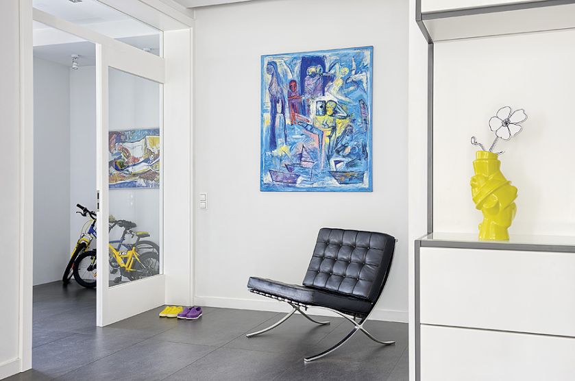 Ciepłym kolorom wnętrz przeciwstawia się eksplozja barw z wiszących na ścianach obrazów. Prawie wszystkie namalował