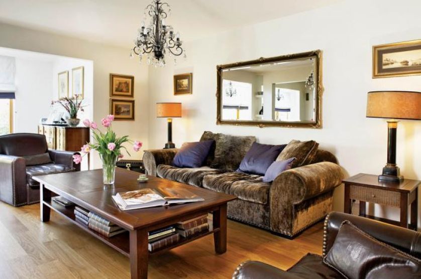 Skórzane fotele i drewniany stolik. Przepis na przytulny dom