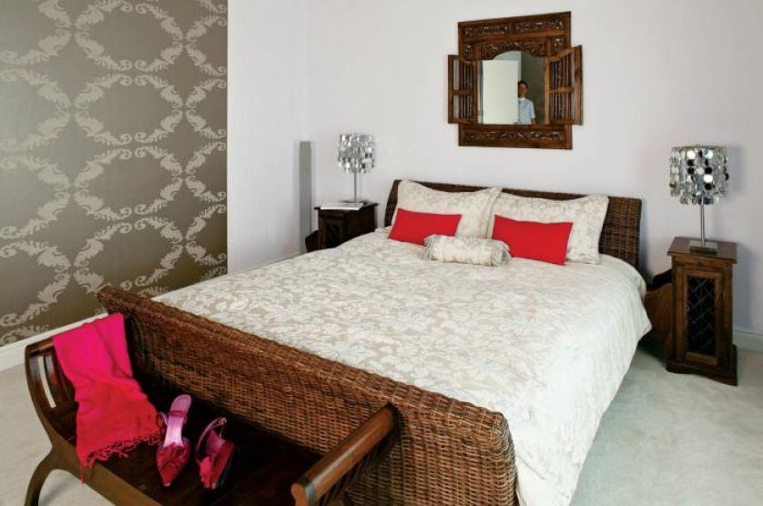 W sypialni uwagę zwraca tapeta zdobiona roślinnymi ornamentami.