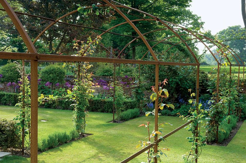 Dwa hektary otoczone wodą, z resztkami starych ceglanych murów, różanymi pergolami, równiutkimi żywopłotami. Im dalej