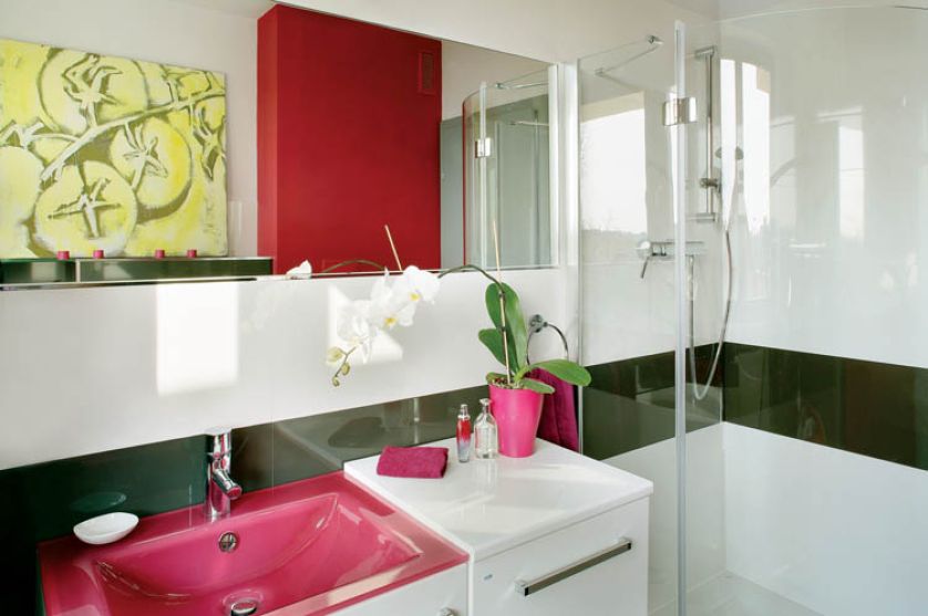 Monotonną biel ścian lamie czarny pas płytek i pomalowany pod kolor do umywalki pion kanalizacyjny.