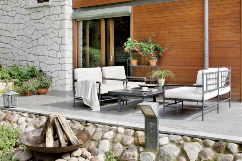 Na tarasie stoją dizajnerskie fotele Unopiu. Obok palenisko wzorowane na marokańskim kociołku.