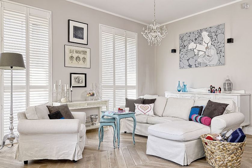 Tłem dla sztuki są białe ściany i jasne meble.