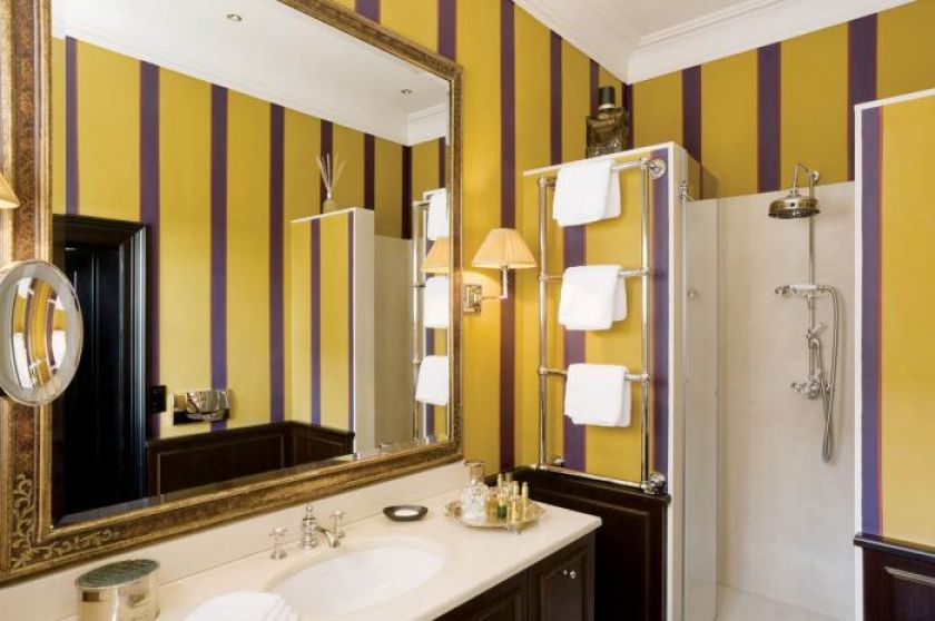 Duże lustro w zdobionej ramie. Apartament pełen smaków