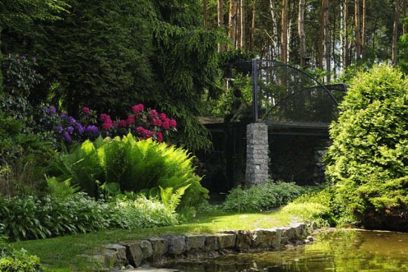 Na tyłach ogrodu tuż przy niewielkiej sadzawce jest brama zrobiona ze starych słupów telegraficznych. Prowadzi