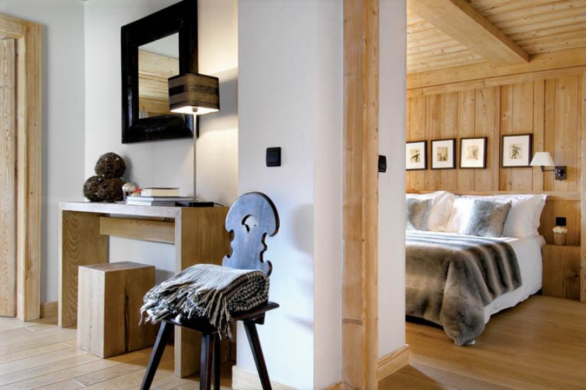 Surowe drewno, biel ścian, do tego proste i naturalne dekoracje w odcieniach czerni, bieli i szarości.