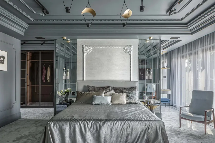 elegancka sypialnia z łóżkiem, tapetą w sztukateryjnej ramie i ścianą z lustrzanych płytek