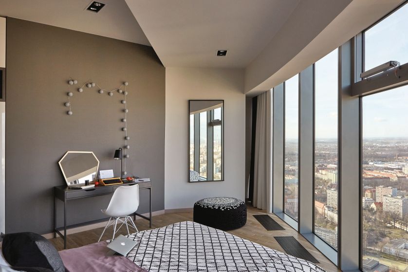 Urządzony w Ikei kącik z toaletką na tle wyraźnej czarnej ściany. Przy lustrze unikatowy puf z Monomoka Gallery.