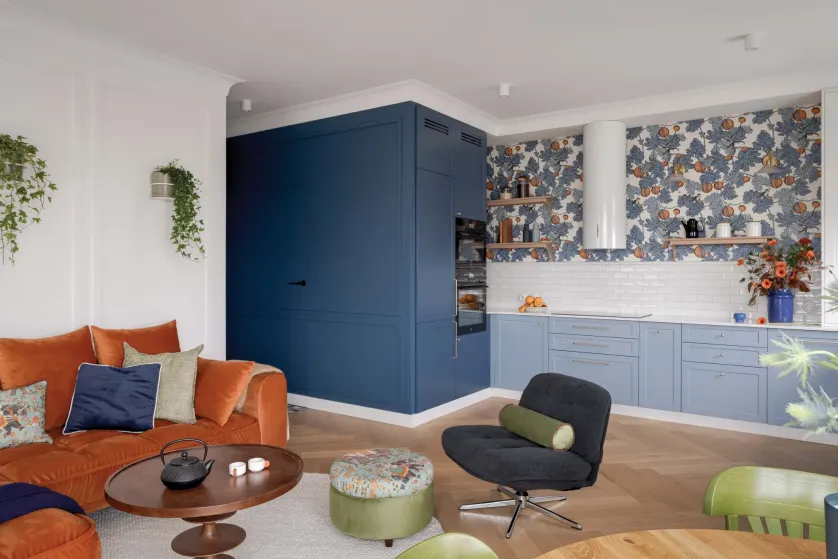 pomarańczowy narożnik w salonie z kuchnią