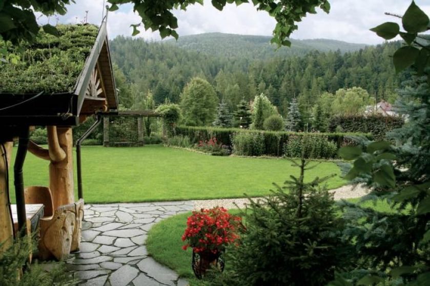 Przed domem rozciąga się szeroki trawnik.