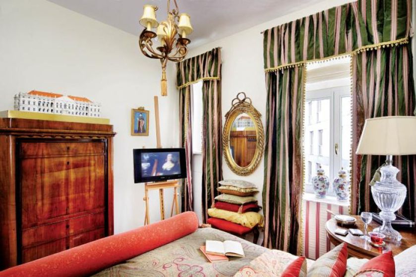 Telewizor na sztalugach wygląda jak obraz. Dzięki temu nie rzuca się w oczy w barokowej sypialni.