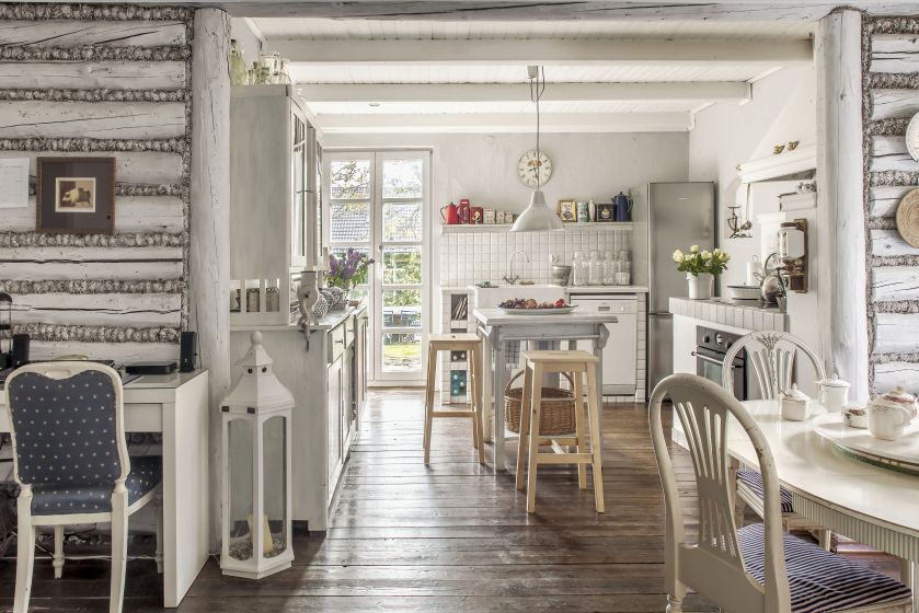 Nietypowy układ kuchni: szafki znajdują się na trzech ścianach, a na środku ustawiono wyspę – wysoki stolik. Fot. Rafał