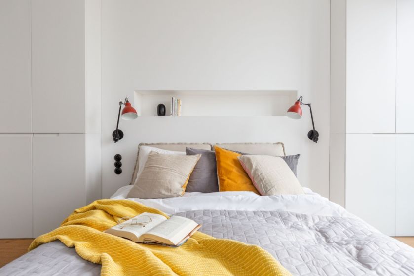 Białe ściany i żółte dodatki w sypialni