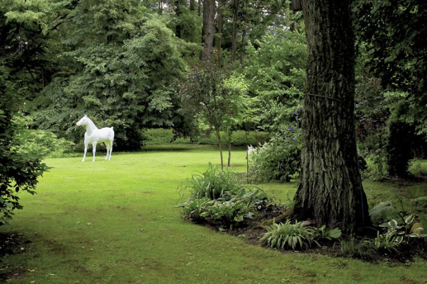 Biały koń w ogrodzie - od razu widać, że w domu mieszka artysta.