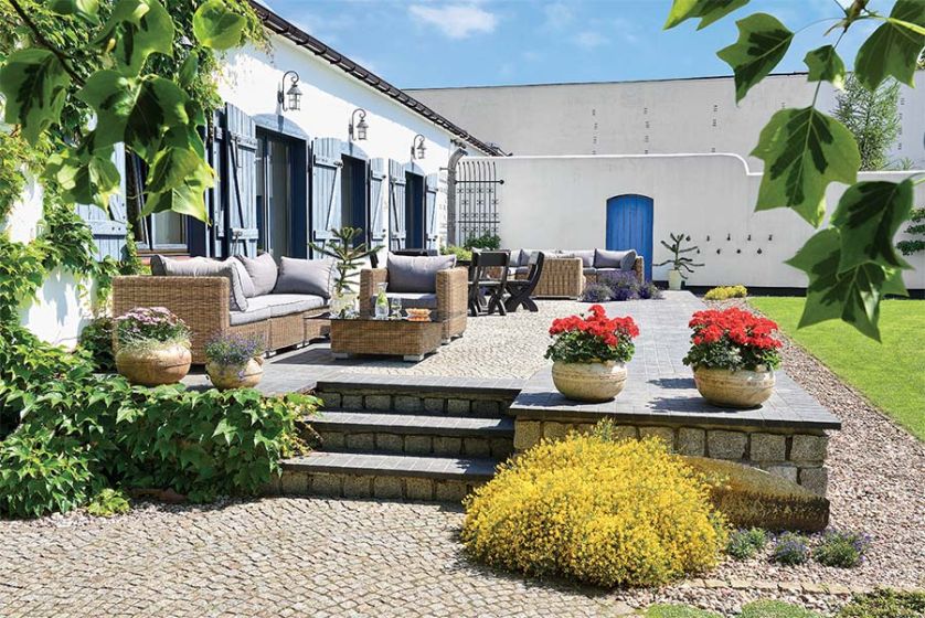 Bielone ściany pawilonu z błękitnymi okiennicami.