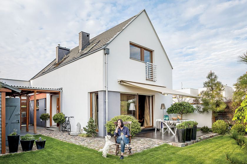 Dom na osiedlu gotowych domków ma prostą bryłę, a w środku urządzony jest i antykami i współczesnymi dizajnerskimi meblami.