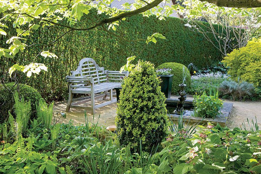 Drewniana, romantyczna ławka. Tulipany wśród bukszpanów