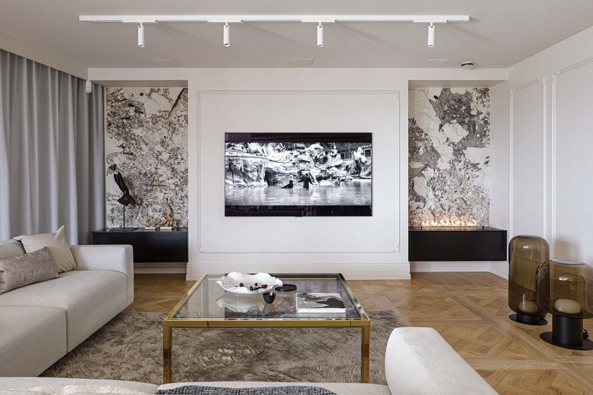 telewizor w salonie obramowany sztukaterią i biokominkiem w kamiennej obudowie