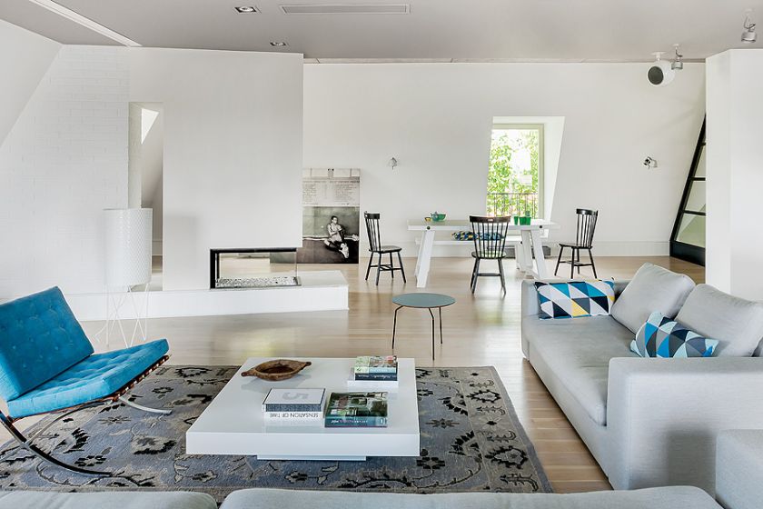 Evergreen czyli fotel Barcelona Miesa Van Der Rohe - klasyk w turkusach. Pod oknem drewniany stół i krzesła ze